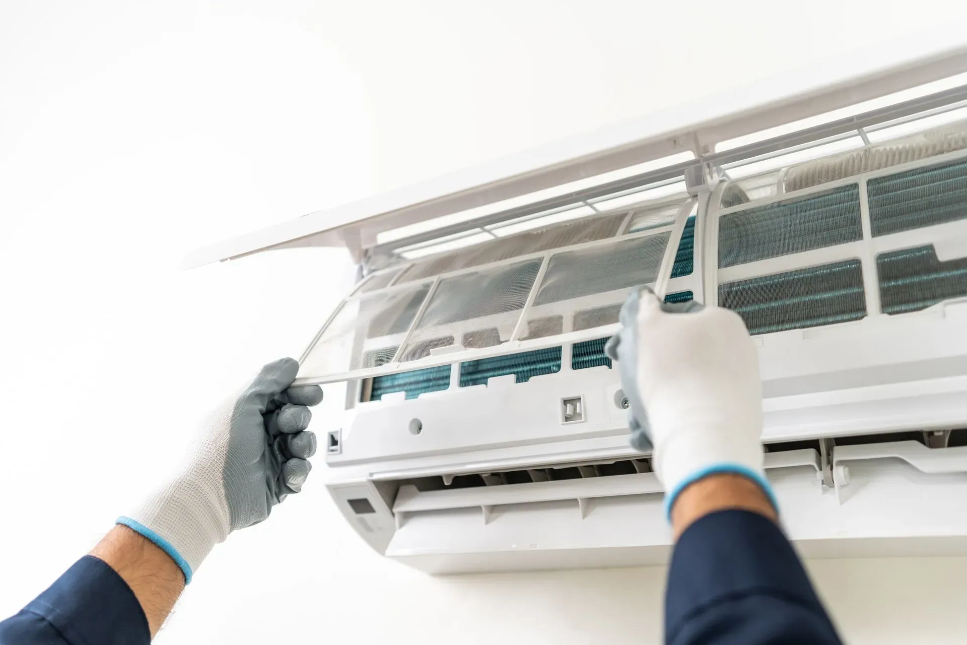 Technician servicing a wall-mounted air conditioner